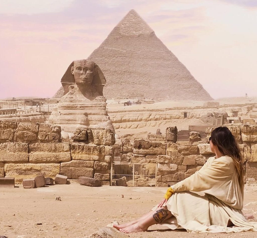 A picture of a woman in front of the Giza Pyramids