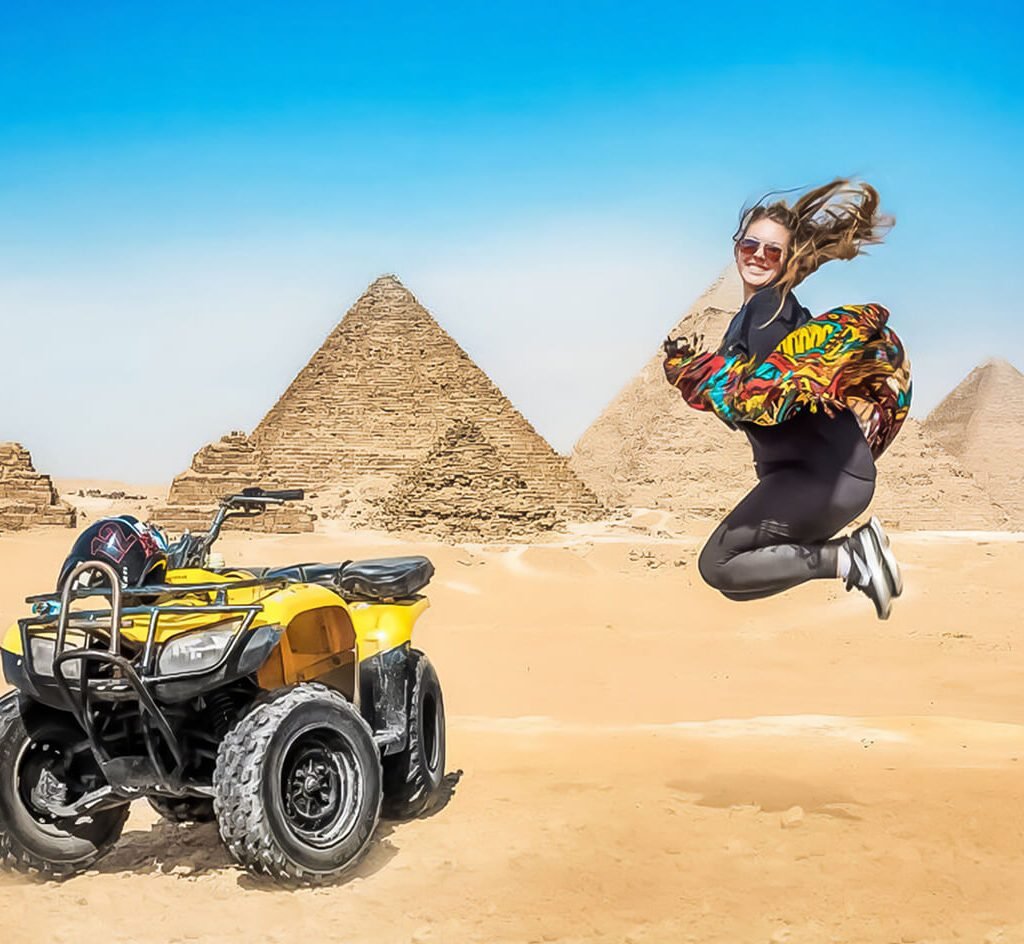 A wonderful shot of a tourist with a quad bike in front of the Pyramids of Giza