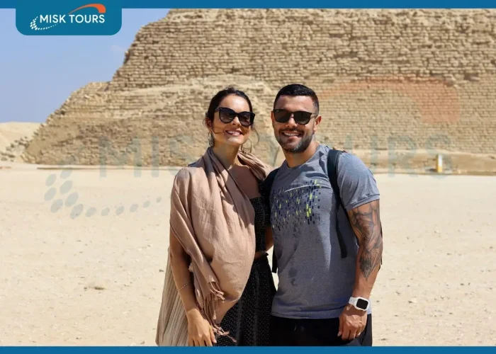 happy-couple-tourists-smiling-in-front-of-step-pyramid-of-djoser-saqqara.