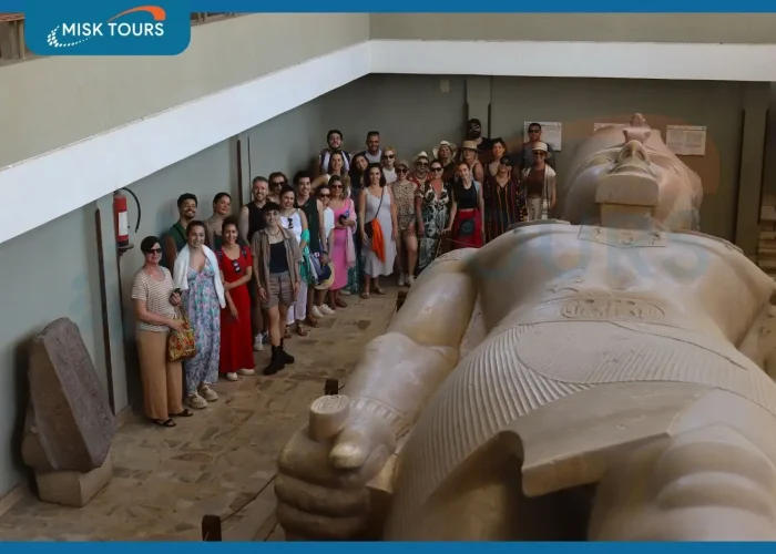 large-group-of-tourists-posing-beside-the-colossal-lying-statue-of-ramesses-ii-at-memphis-museum.