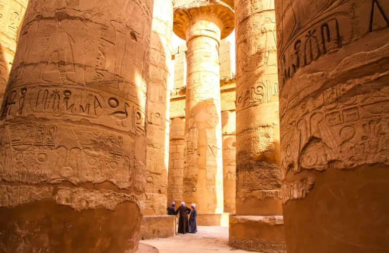 Ancient hieroglyphics carved into massive stone pillars at Karnak Temple in Luxor, a top historical site to explore while visiting Egypt in January.