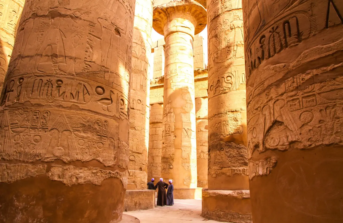 Ancient hieroglyphics carved into massive stone pillars at Karnak Temple in Luxor, a top historical site to explore while visiting Egypt in January.