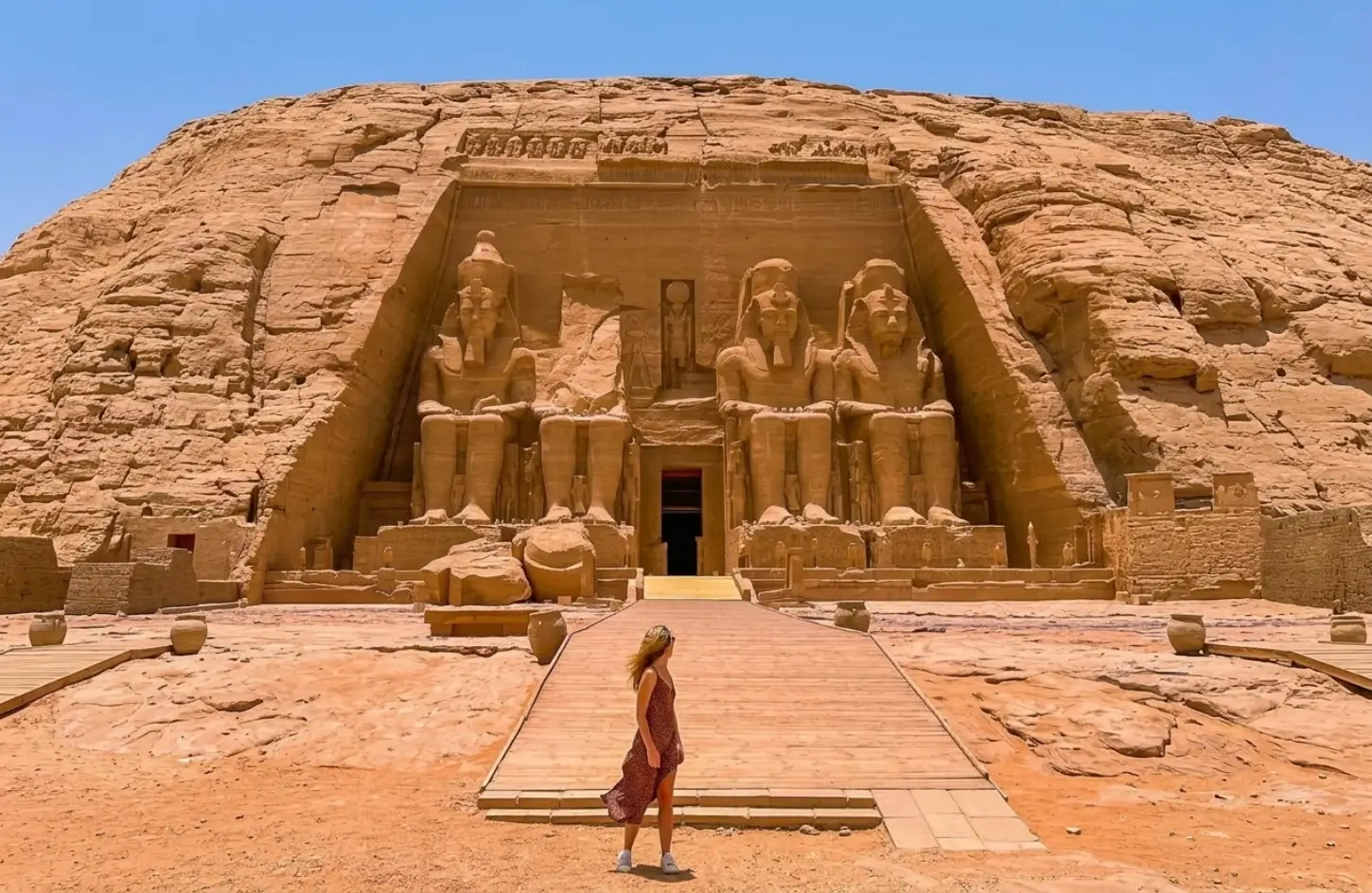 A female tourist walking toward the Great Temple of Ramesses II at Abu Simbel, demonstrating that it is safe to travel to Egypt.