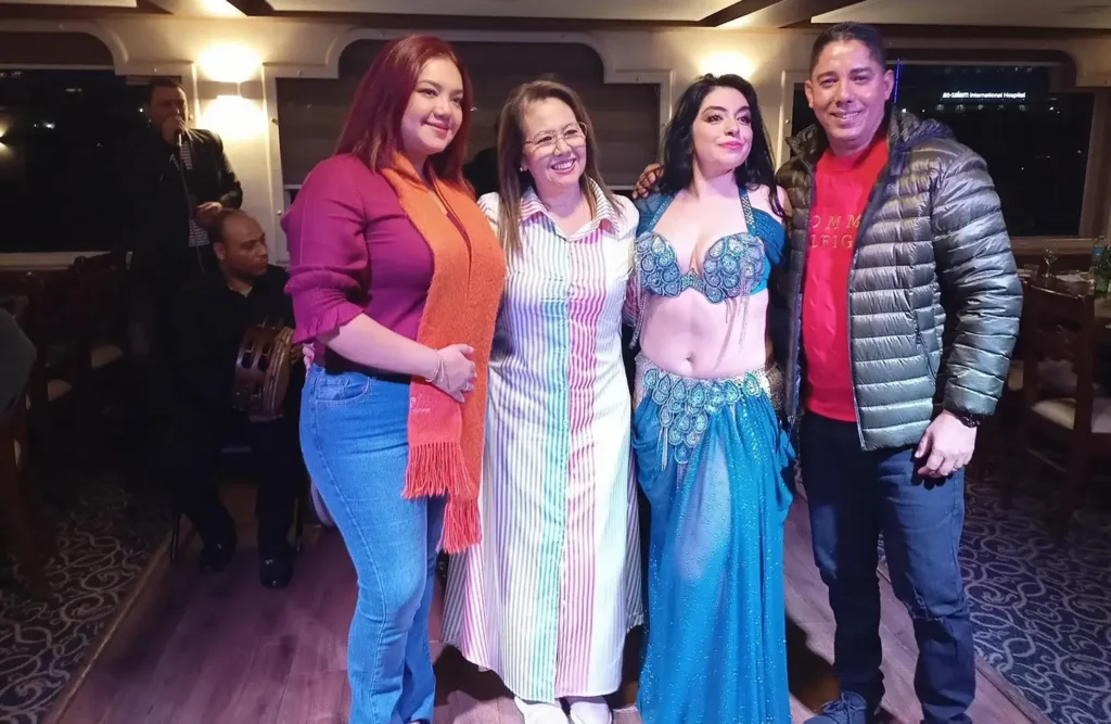 A stunning image of a group of people posing with a belly dancer on a cruise ship