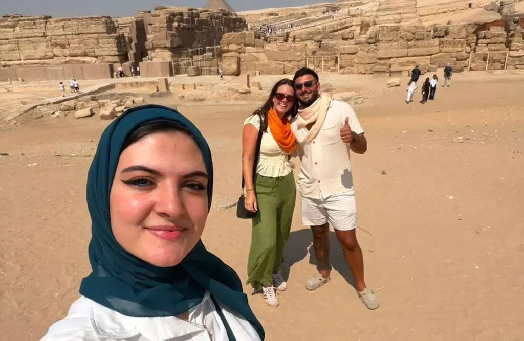 A stunning image of a woman taking a selfie with a couple in front of ancient egyptian ruins