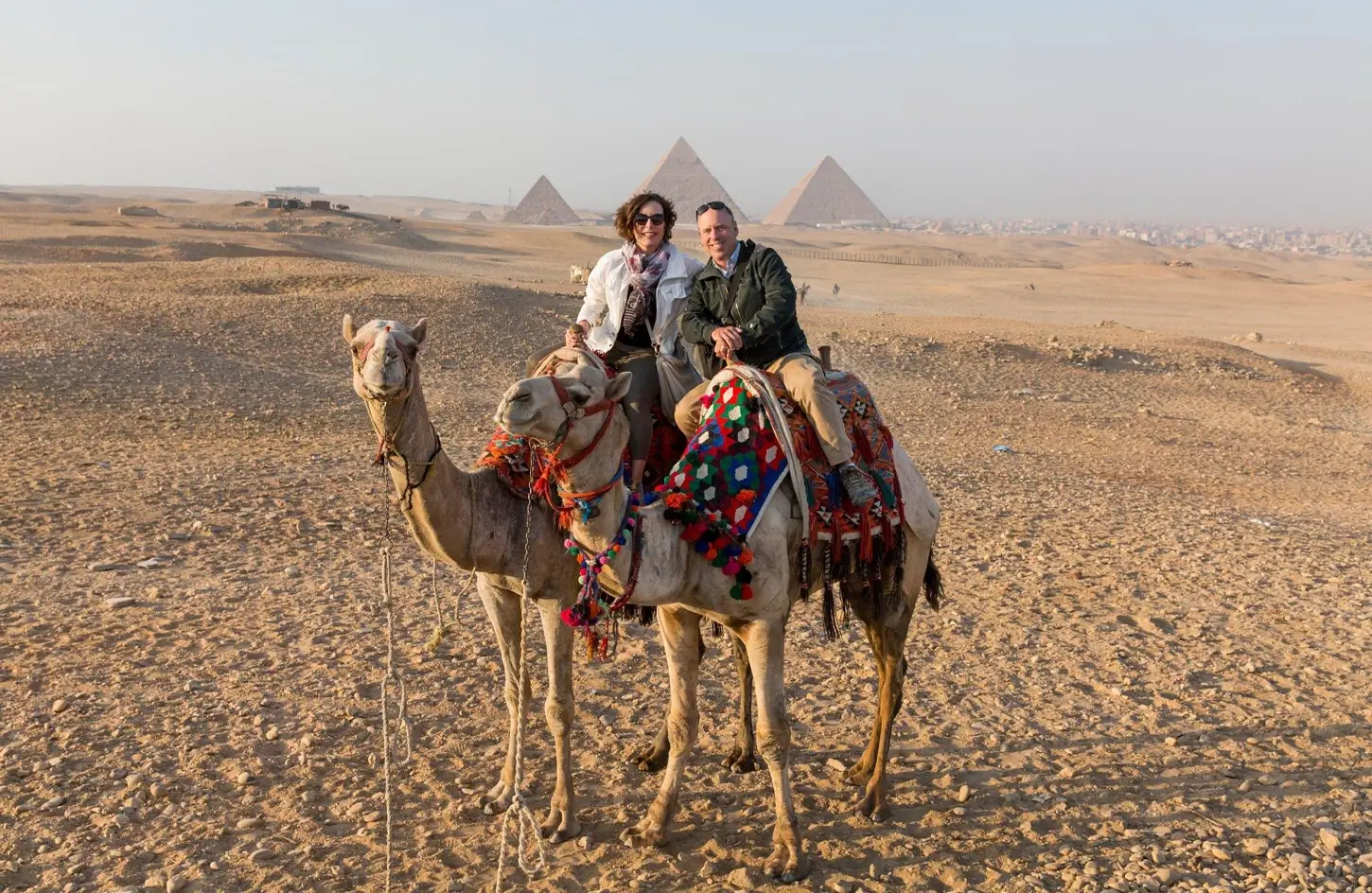 Couple riding camels near the Giza Pyramids